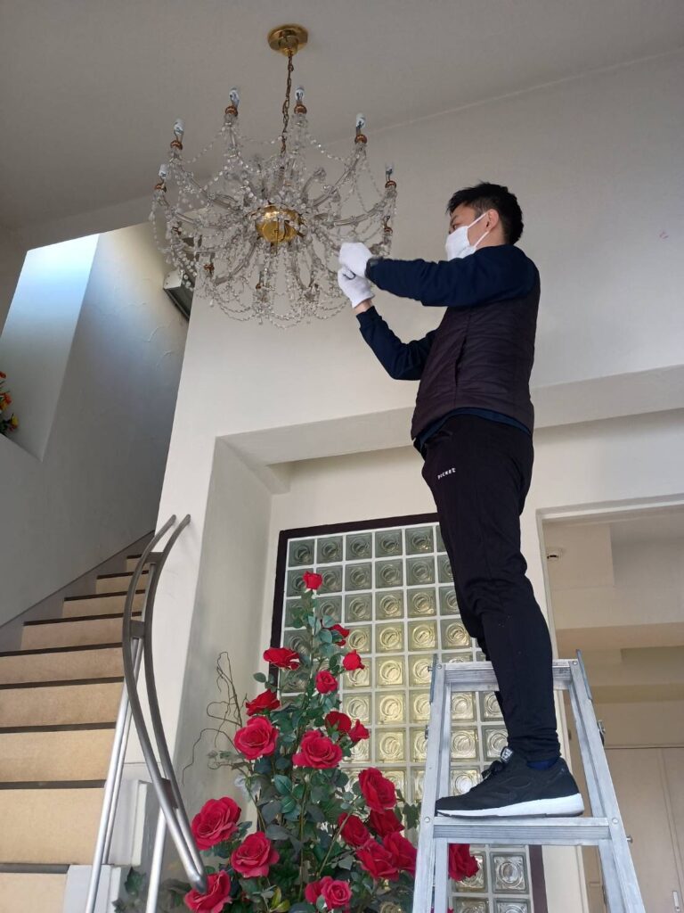 河原郁子NY・シャンデリア東京の専門スタッフがシャンデリアをハンドクリーニングしている様子の画像