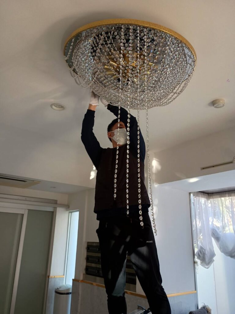 河原郁子NY・シャンデリア東京の専門スタッフによるデザイナーズシャンデリアの専門クリーニングしている画像